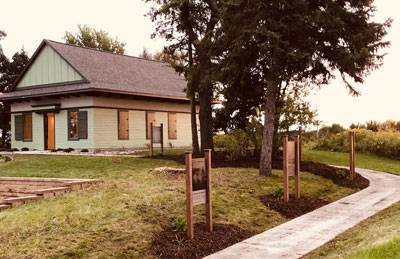 Photo of old White Bea Town Hall with interpretative signage leading up to it.