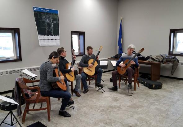 4 people playing guitar